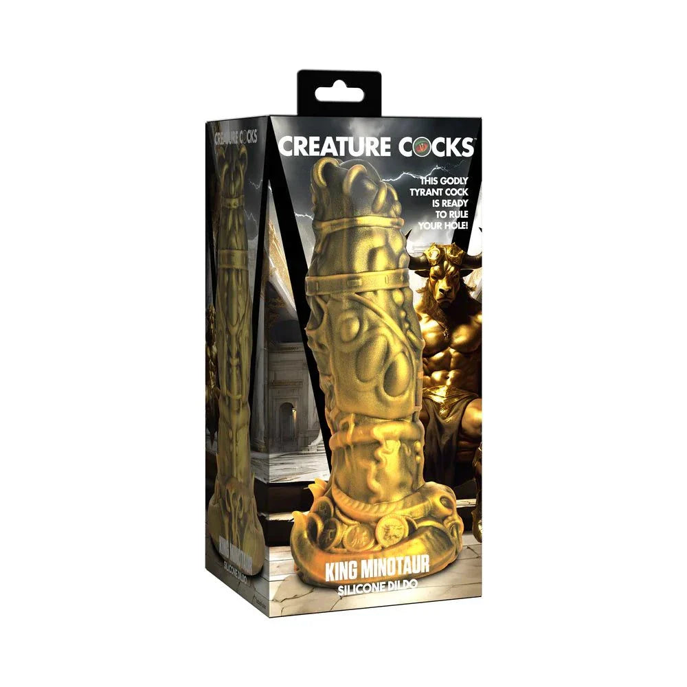Creature Cocks King Minotaur gold-tone silicone dildo with intricate rings, piercings, coins, and suction cup base in packaging.