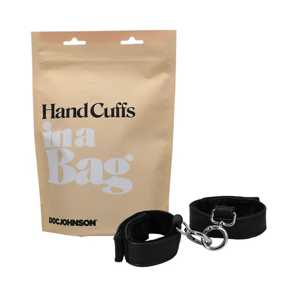 Doc Johnson Hand Cuffs in a Bag black faux leather with velvet lining and adjustable Velcro closures for light bondage play.