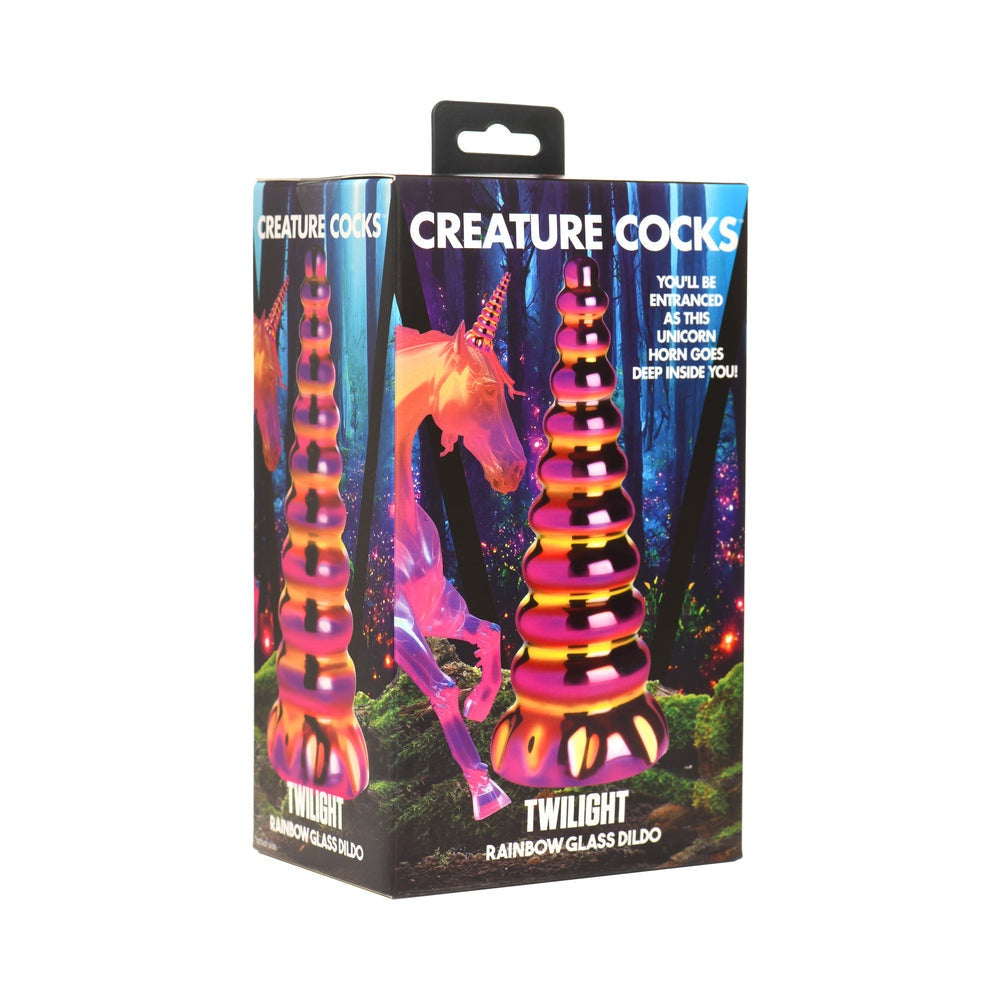 Packaging box of Creature Cocks Twilight Rainbow Glass Dildo with iridescent unicorn horn design against a mystical forest background