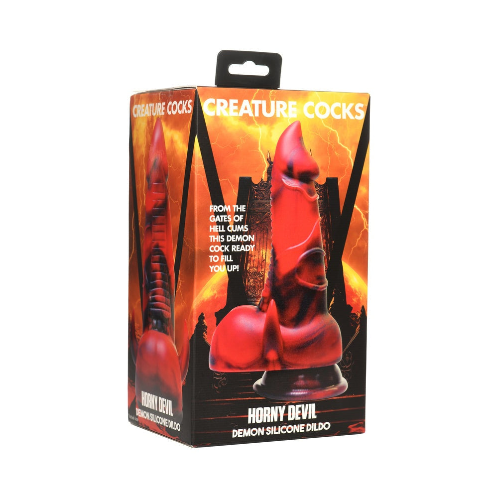 Packaging of Creature Cocks Horny Devil Demon Silicone Dildo featuring a red and black devil-themed dildo with horns and suction base against a fiery background