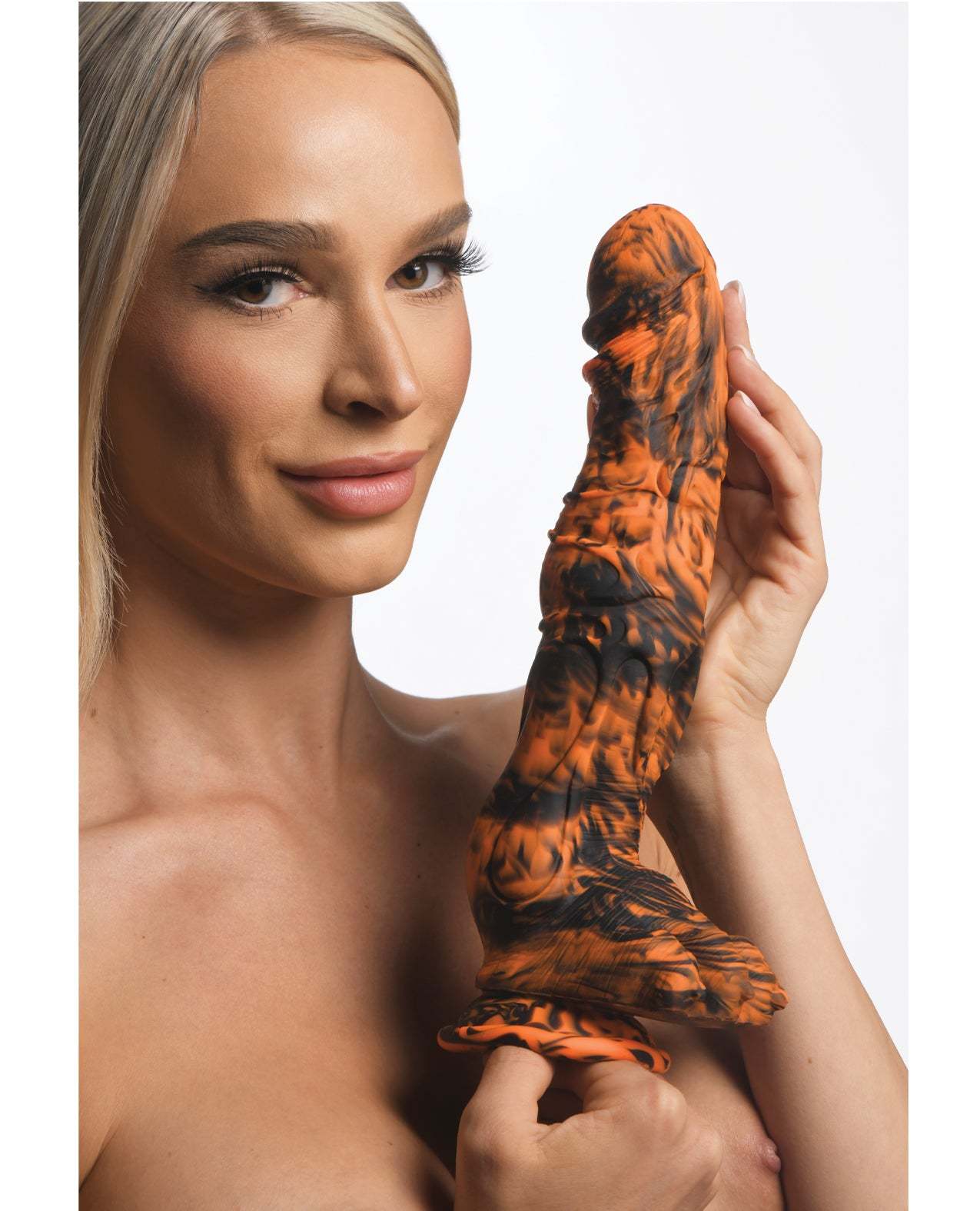 Woman holding Creature Cocks Sabertooth Silicone Dildo in orange and black camo design