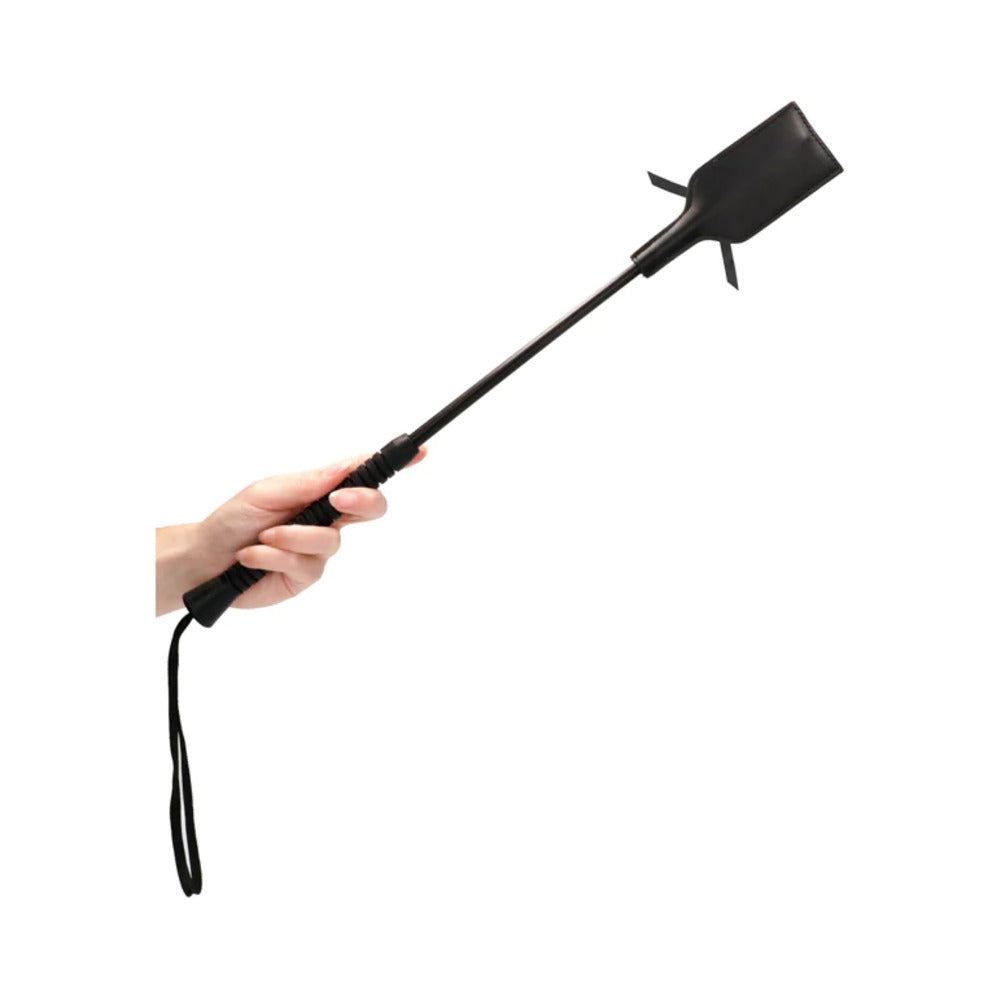 Black Ouch Laced-Up Crop with short handle and rectangular head held in hand