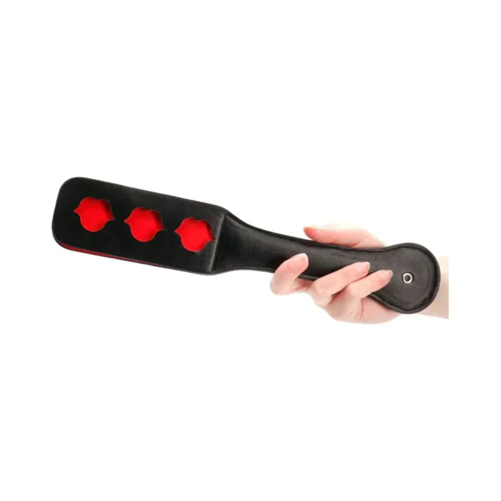 Black leather Ouch! Lip Pattern Paddle with three red lips on one side held in hand