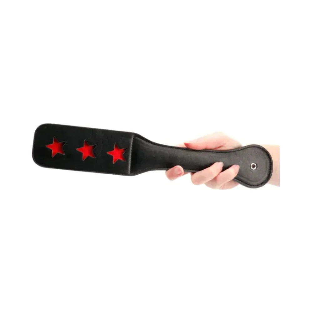 Black leather paddle with three red star-shaped cutouts held in hand, Ouch! Star Pattern Paddle design