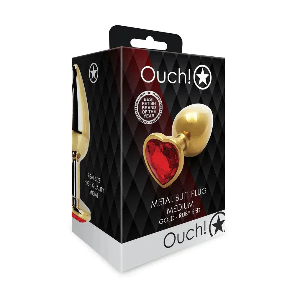 Packaging of Ouch! Heart Gem Butt Plug Medium size in gold with ruby red gem, showcasing a metal butt plug.