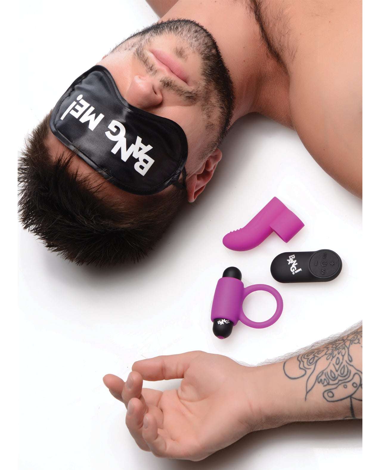 Purple couple's kit with RC bullet, love ring, finger vibe, and "BANG ME!" satin blindfold on man with tattooed arm