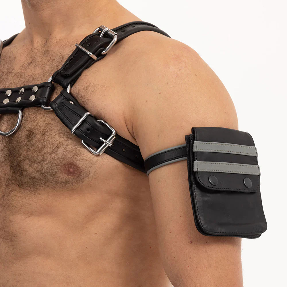 Prowler RED leather pouch strapped to upper arm with adjustable black straps and silver buckles, styled with harness accessory.