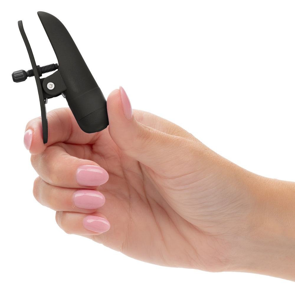 Black rechargeable Nipple Play Nipplettes vibrating nipple clamps in hand, showcasing adjustable design for enhanced pleasure.