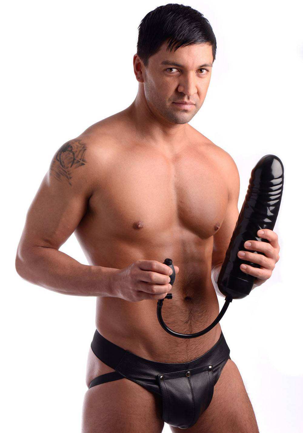 Man holding black XXL inflatable dildo with pump in leather underwear