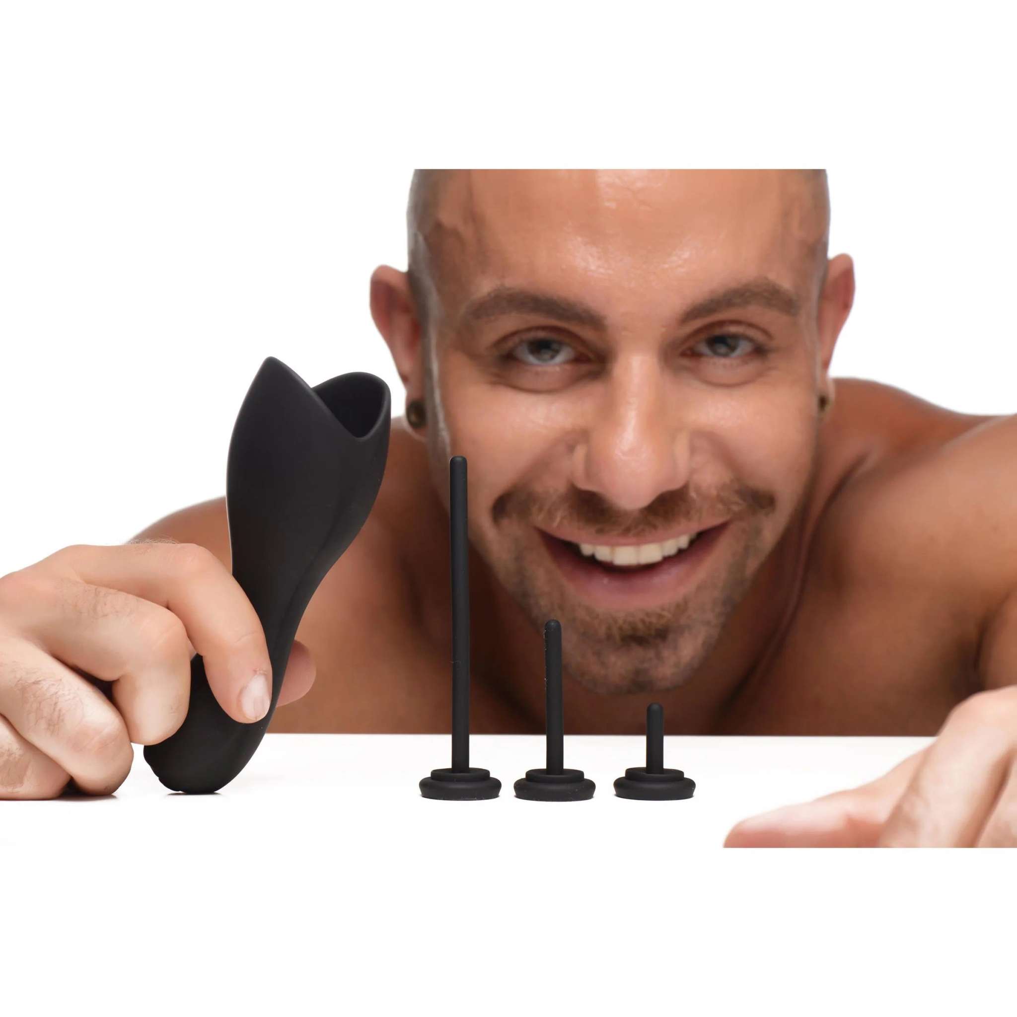 Black vibrating penis head teaser with three urethral sounds in small, medium, and long sizes held by a smiling man