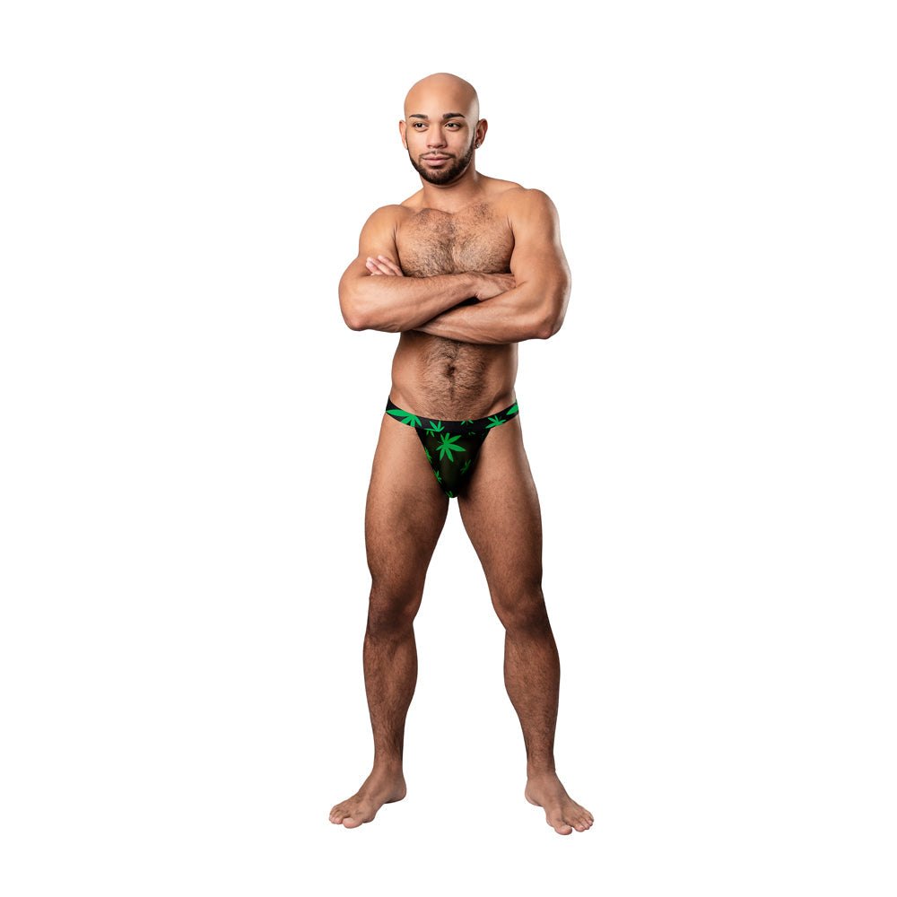 Male model wearing Male Power Hazy Dayz micro thong with green pot leaf print on black sheer stretch mesh fabric