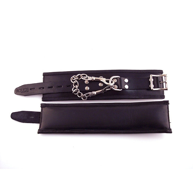 Padded black leather Rouge Wrist Cuffs with adjustable buckles, D-ring, and detachable trigger hook chain for bondage play.