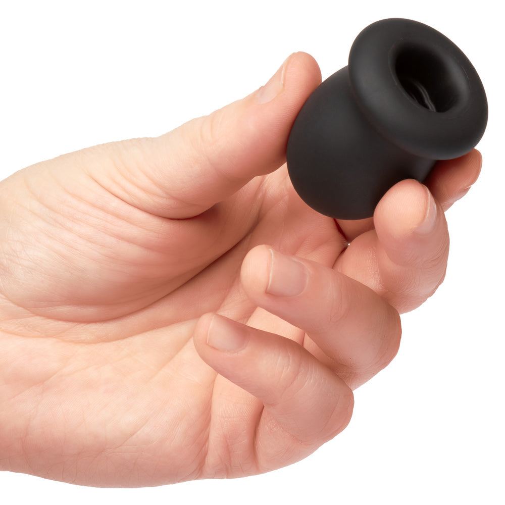 Hand holding Boundless FTM Stroker 2 inch liquid silicone textured male stroker with closed end for suction and easy cleaning