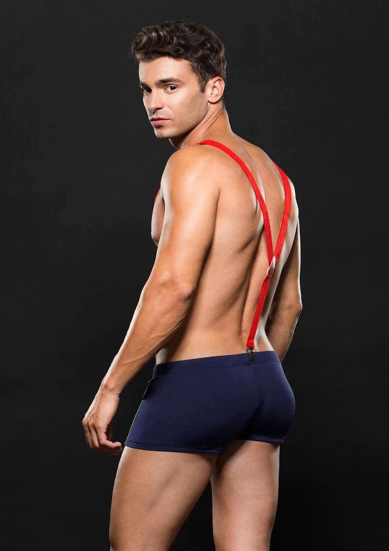 Man wearing navy blue fireman bottom with red suspenders on black background
