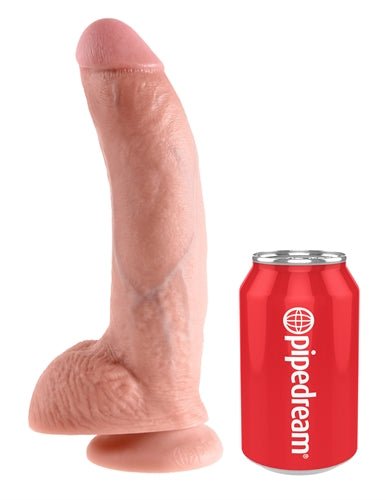King Cock 9-Inch realistic flesh-tone dildo with balls and suction cup base next to a soda can for size comparison
