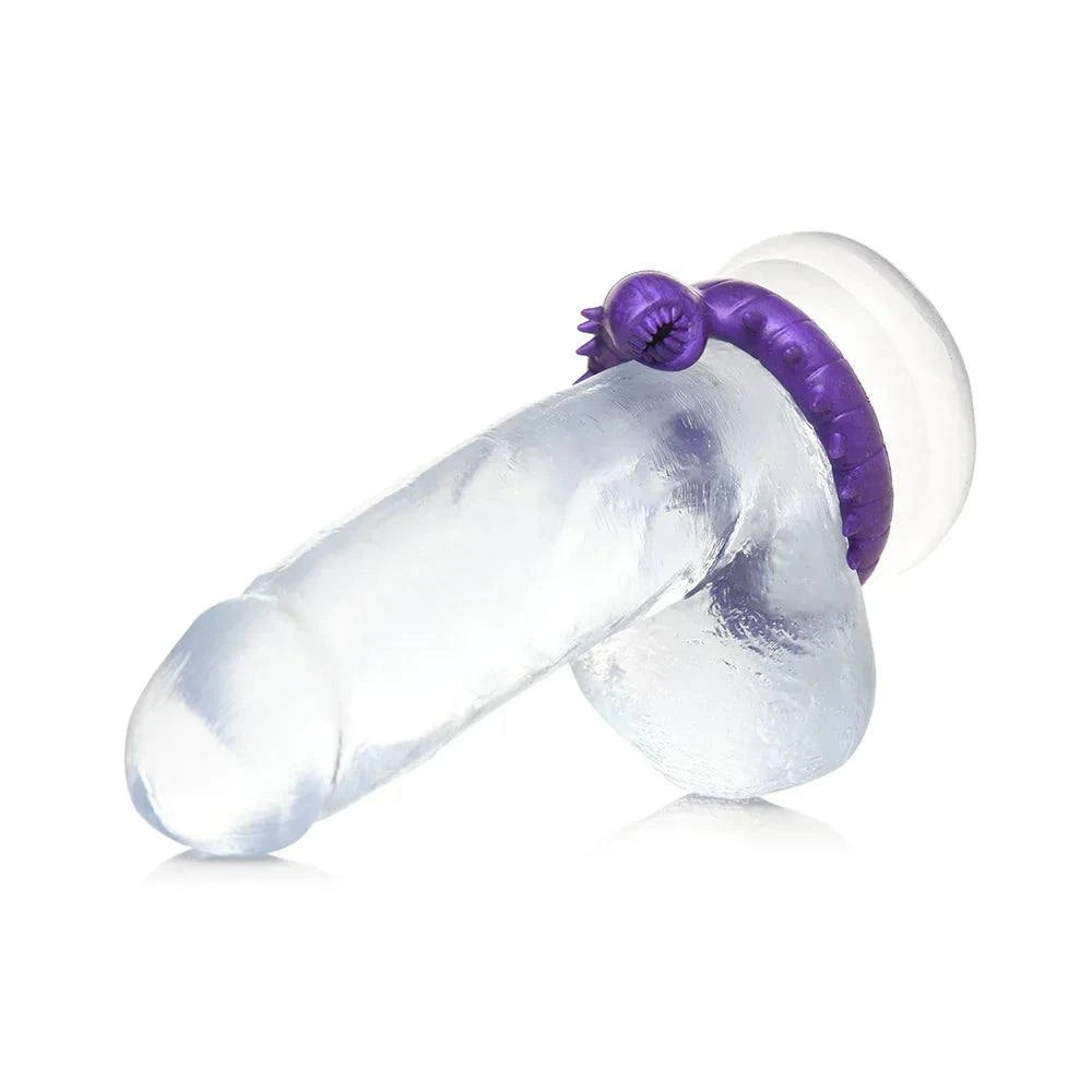 purple silicone cock ring with spikes displayed on a clear dildo