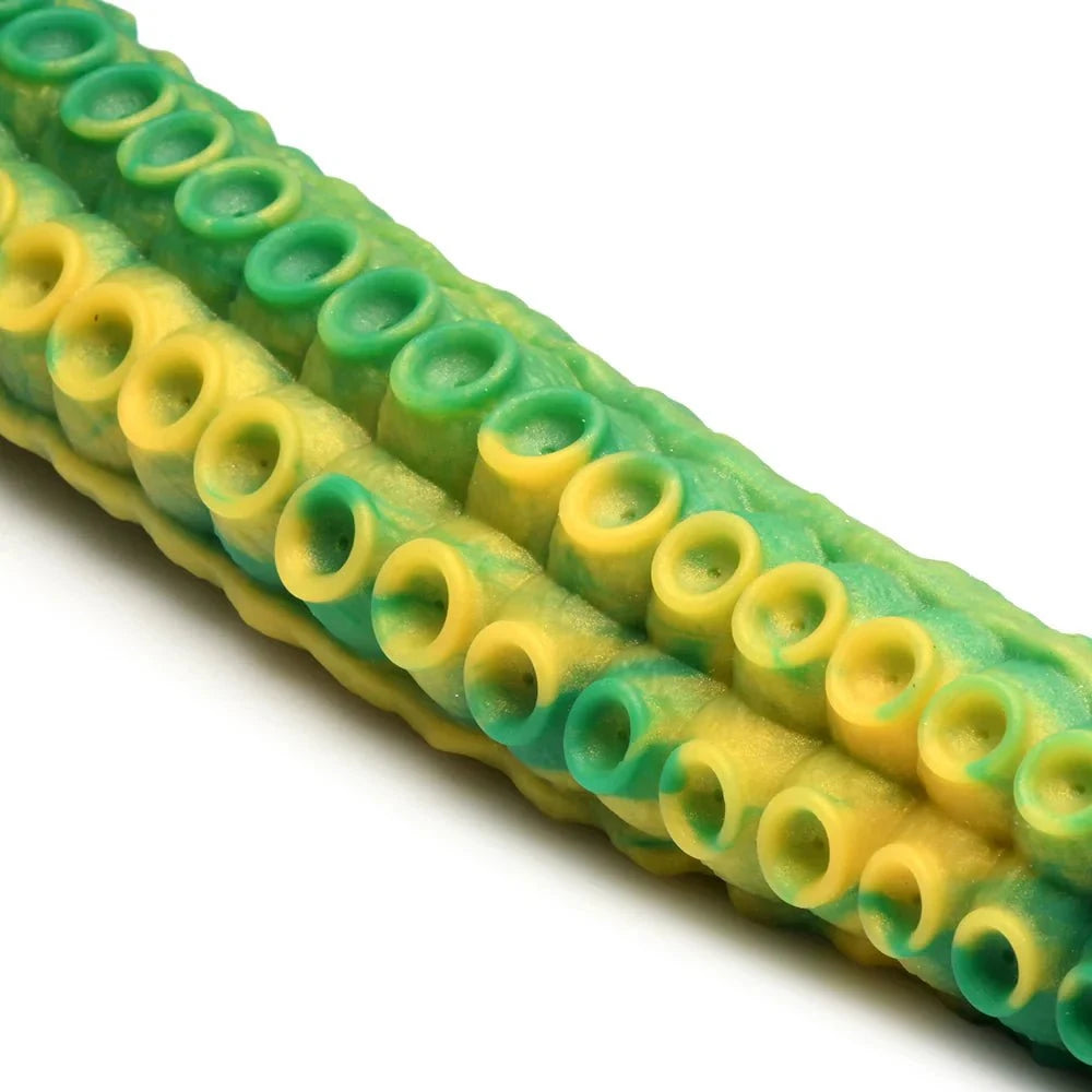 Close-up of green and yellow Creature Cocks Titan Tentacle silicone dildo with textured suckers
