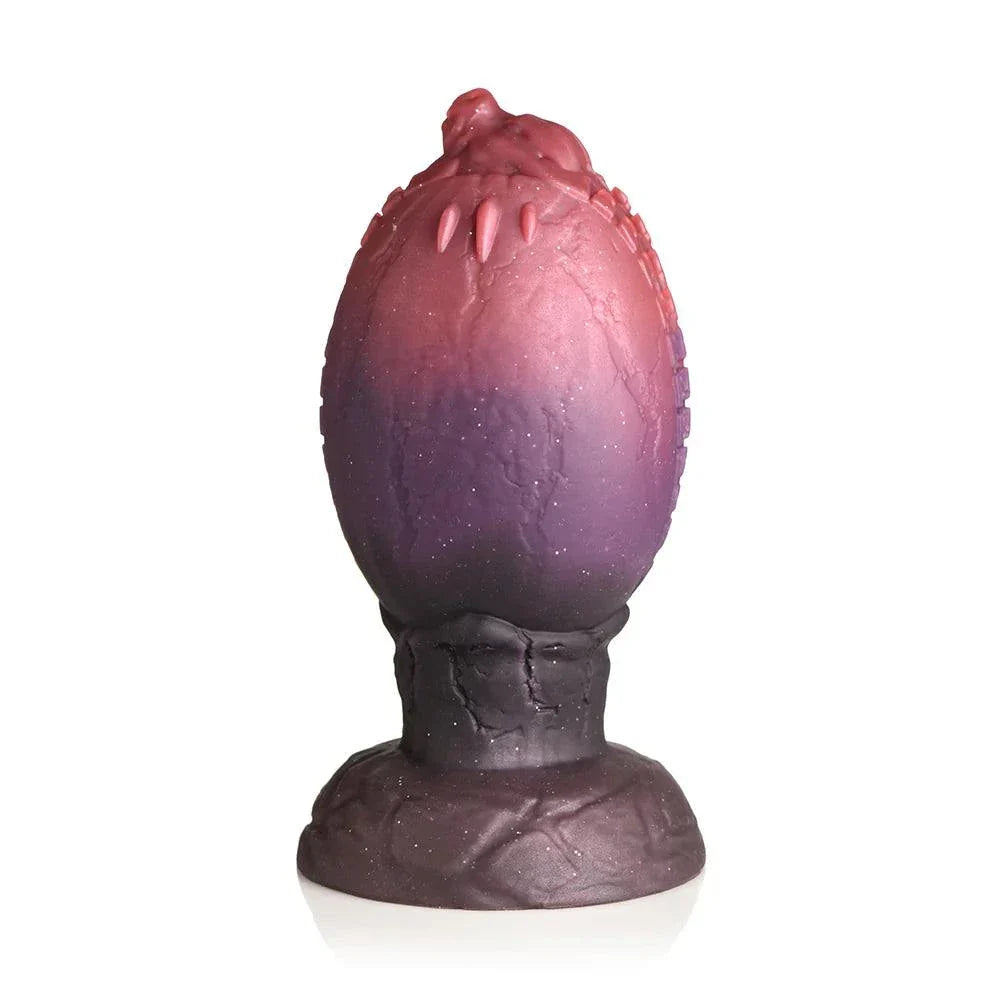 Creature Cocks Dragon Hatch Silicone Egg XL with glittery dark red and brown finish, textured ridges, and dragon-head tip for fantasy play.