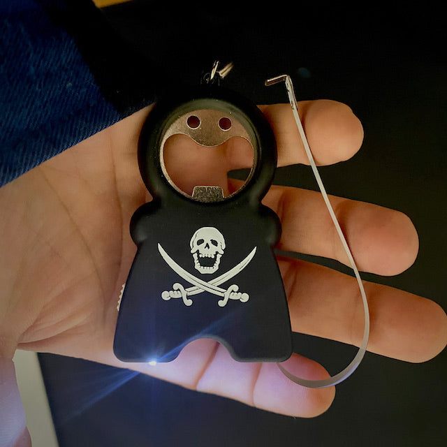 TIM 4-in-1 Keychain with bottle opener, flashlight, tape measure, and skull design in hand