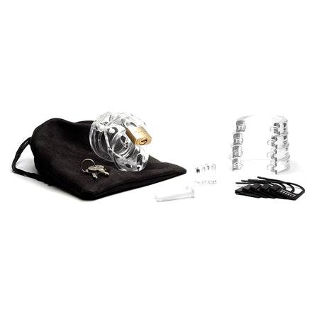 Mini Me Clear Male Chastity device with lock, keys, and accessory parts on a black pouch.
