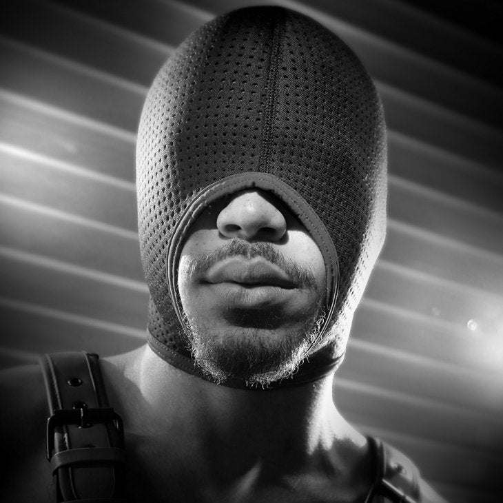Man wearing Fort Troff Black Ops Hood Regular with perforated neoprene fabric and large mouth opening in black and white.