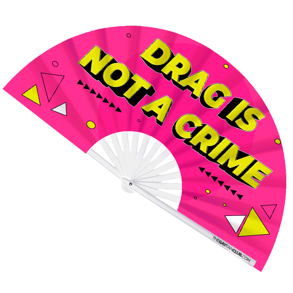 UV-reactive drag hand fan with neon pink background and bold "Drag Is Not A Crime" yellow text