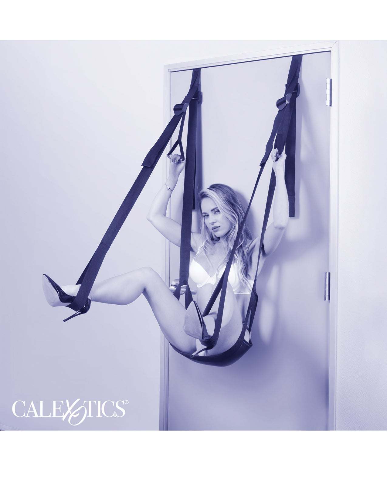 Nocturnal Collection Sex Swing in black hanging on door with woman demonstrating usage