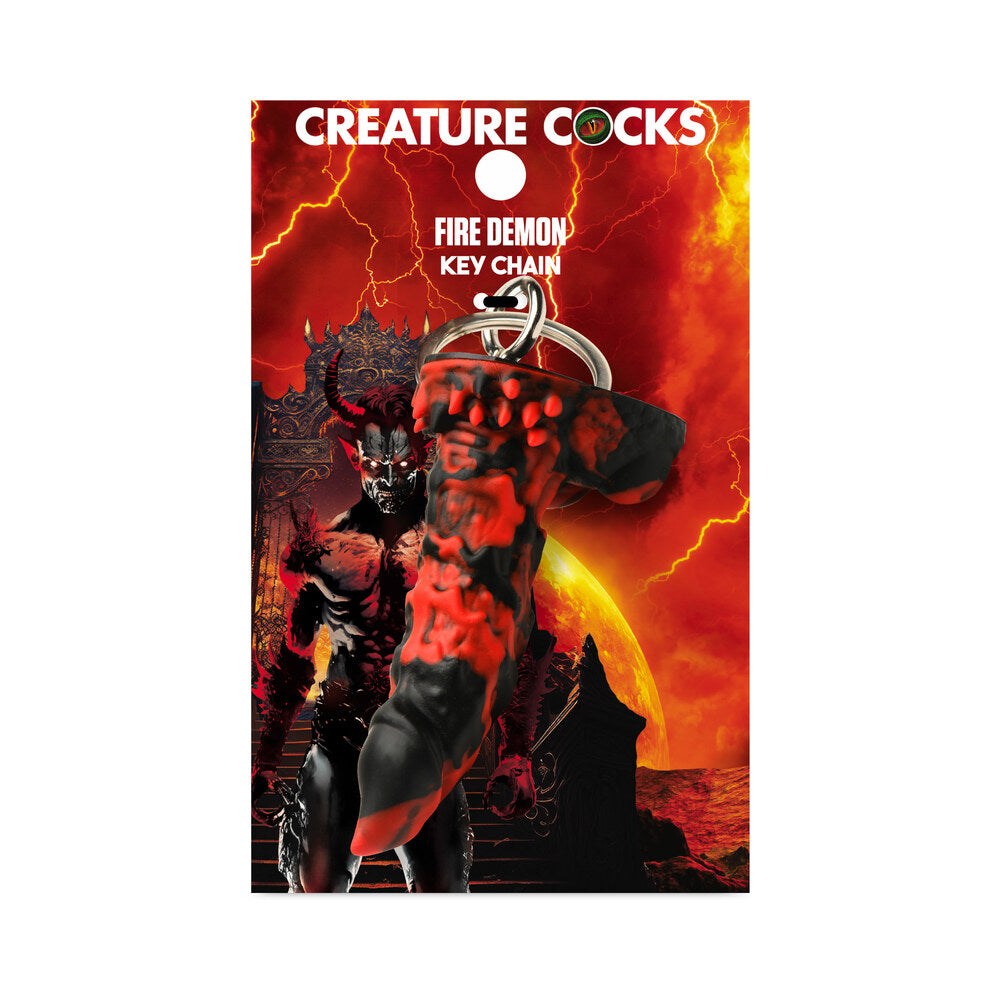 Creature Cocks Fire Demon Keychain featuring a red and black fire demon design, body-safe silicone, and metal ring on fantasy-themed packaging.