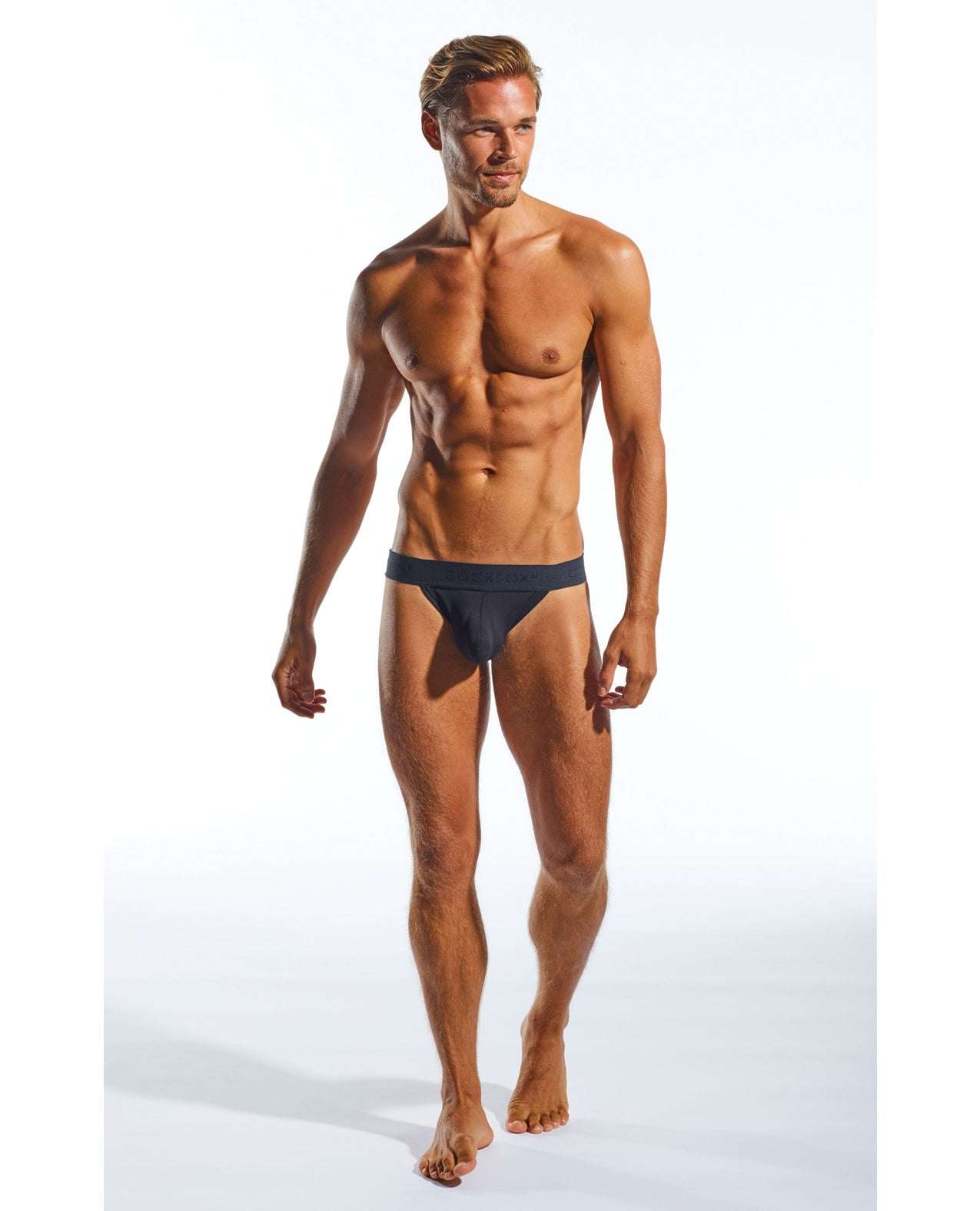 Male model wearing black Cocksox Enhancing Pouch Jockstrap in size large against a white background.