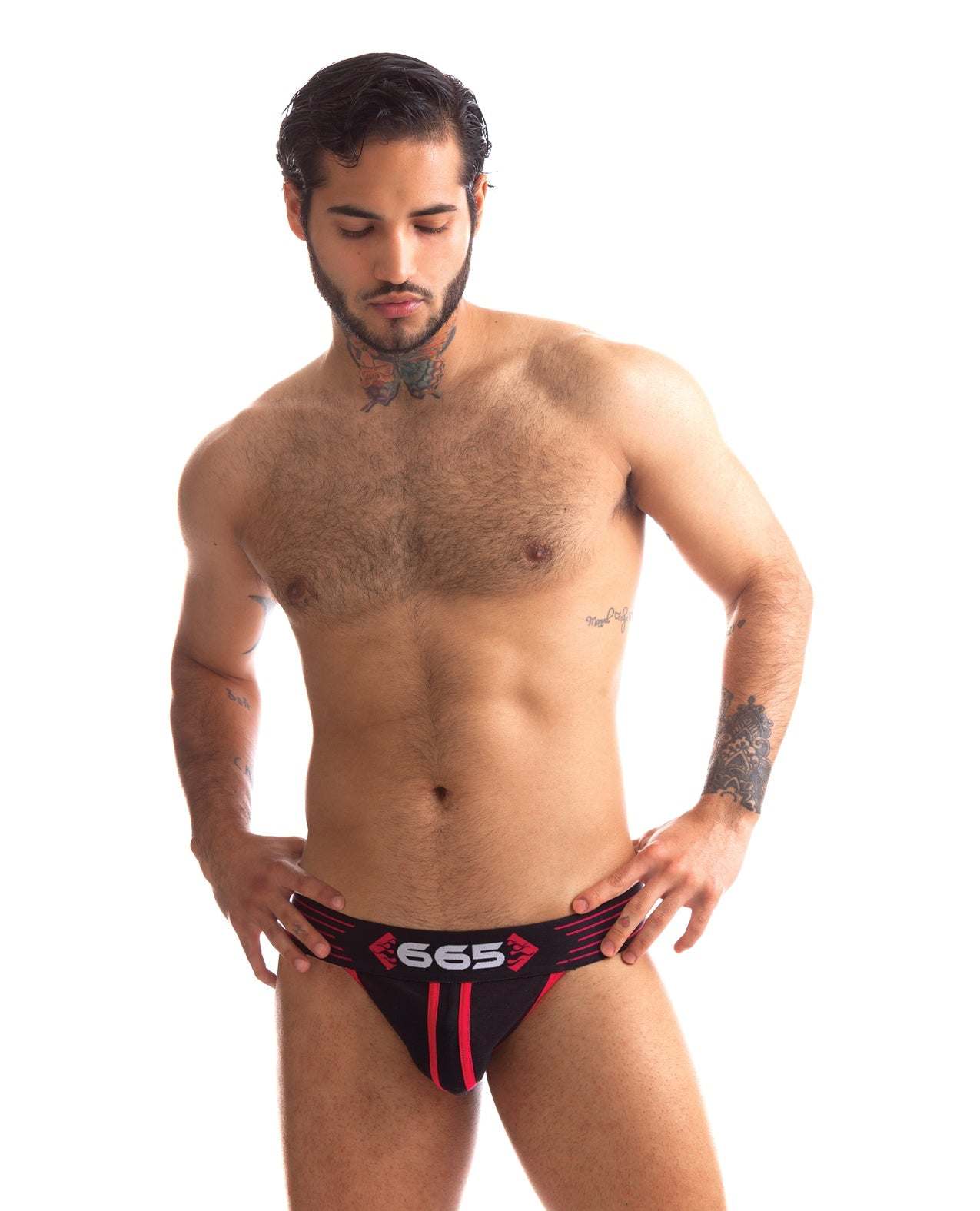 Male model wearing black and red 665 Rally Jockstrap with bold logo waistband against white background