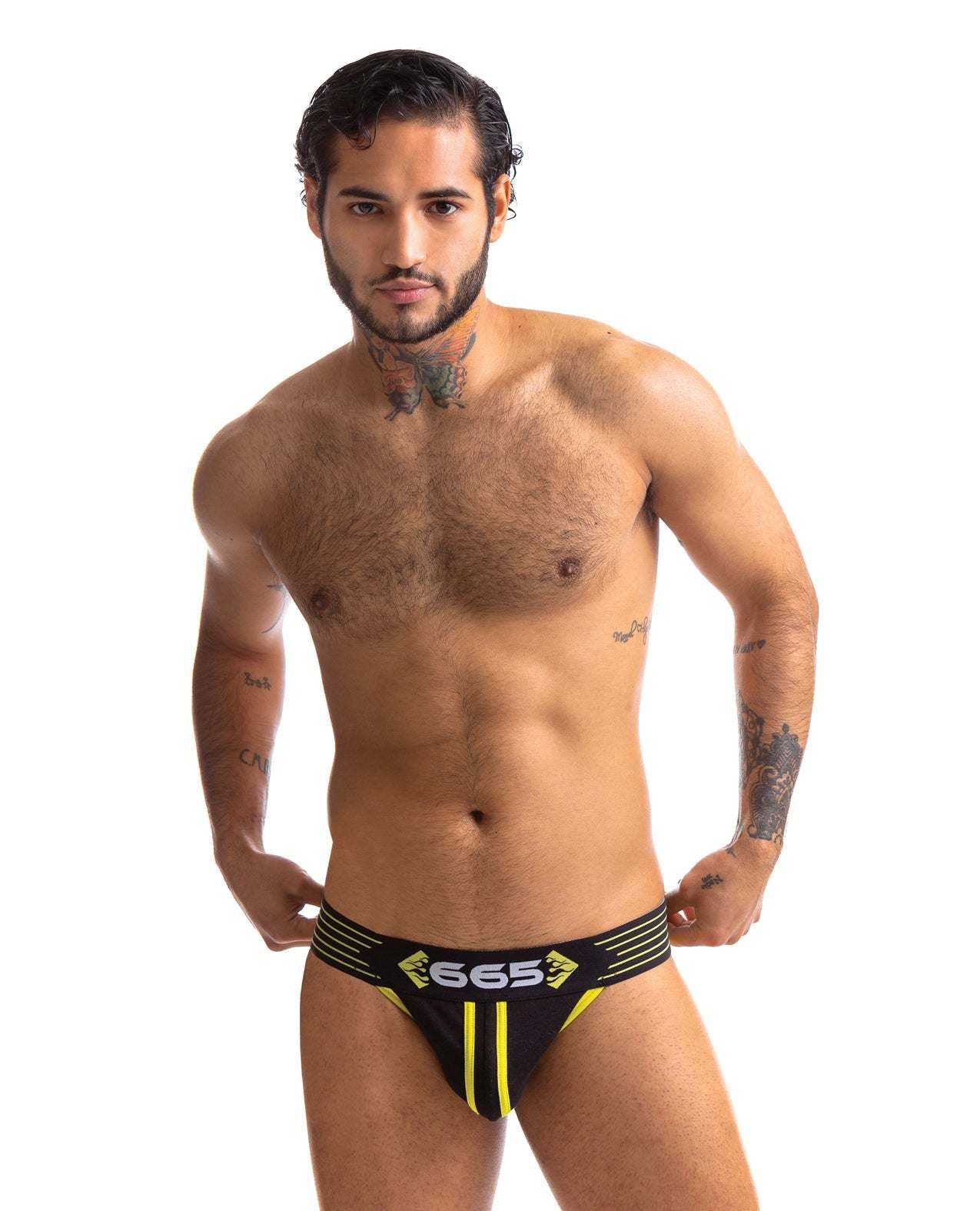 Male model wearing a black and yellow 665 Rally Jockstrap with logo waistband, showcasing fit and style.
