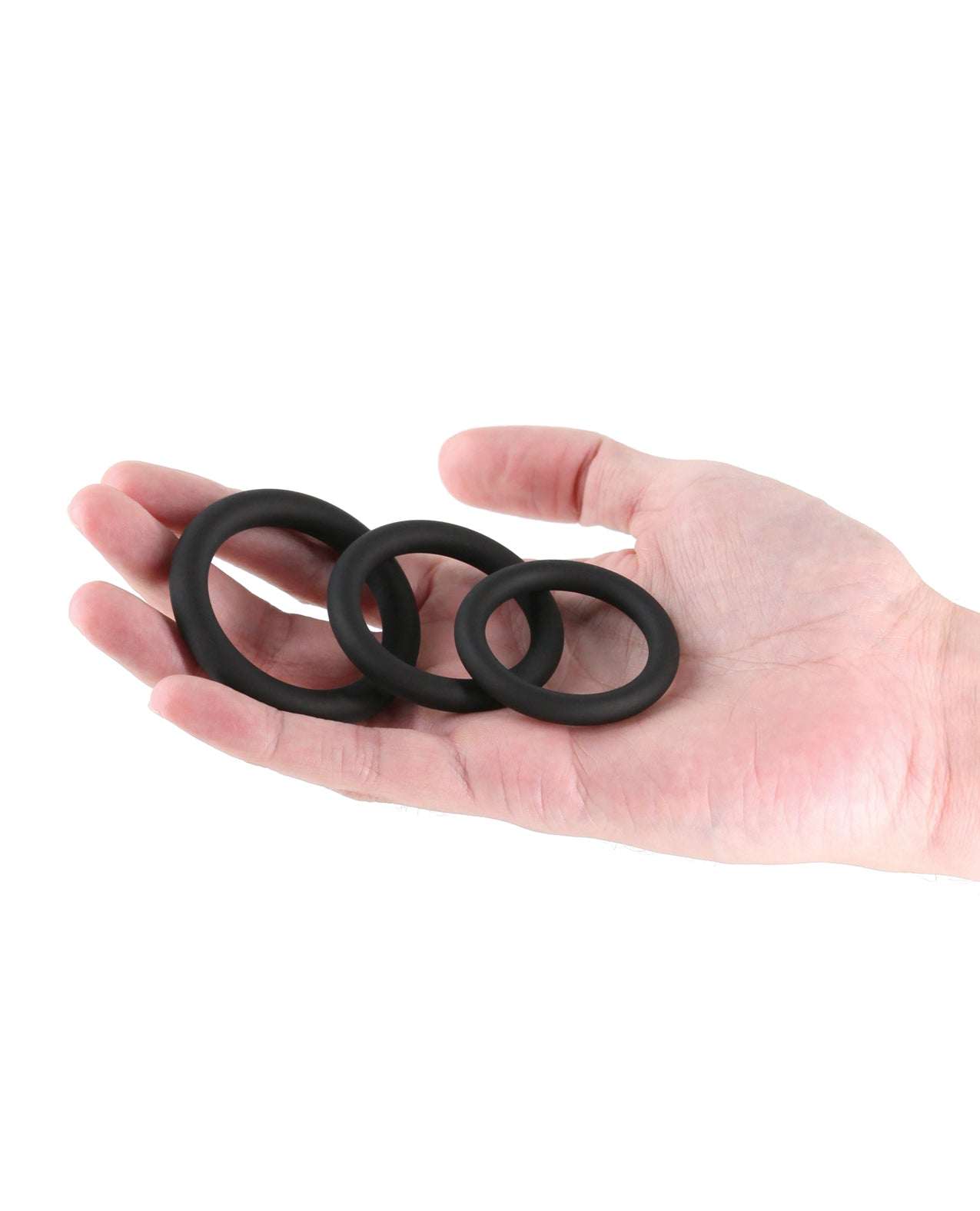 Hand holding three black Renegade Slim Cock Rings in different sizes made of stretchy silicone.