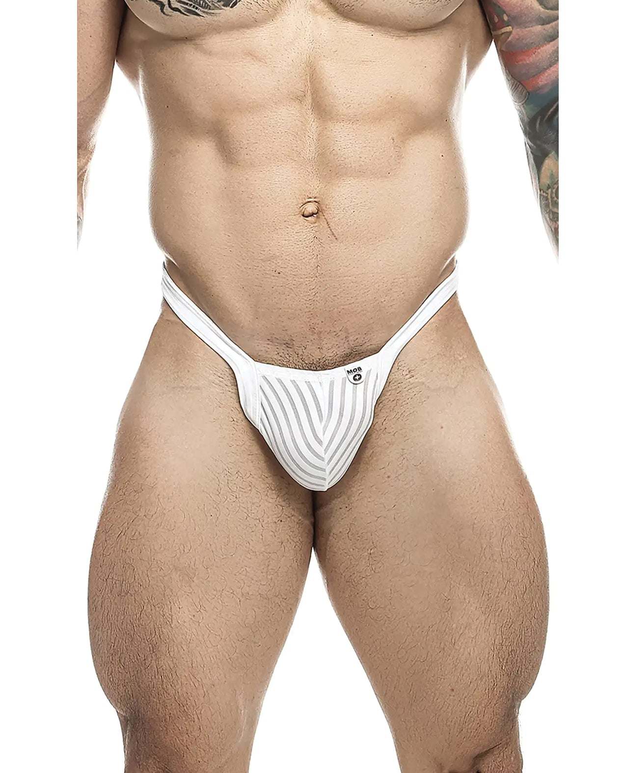 Male model wearing white sheer Male Basics Y Buns Thong showcasing slim V-strap design and supportive pouch.