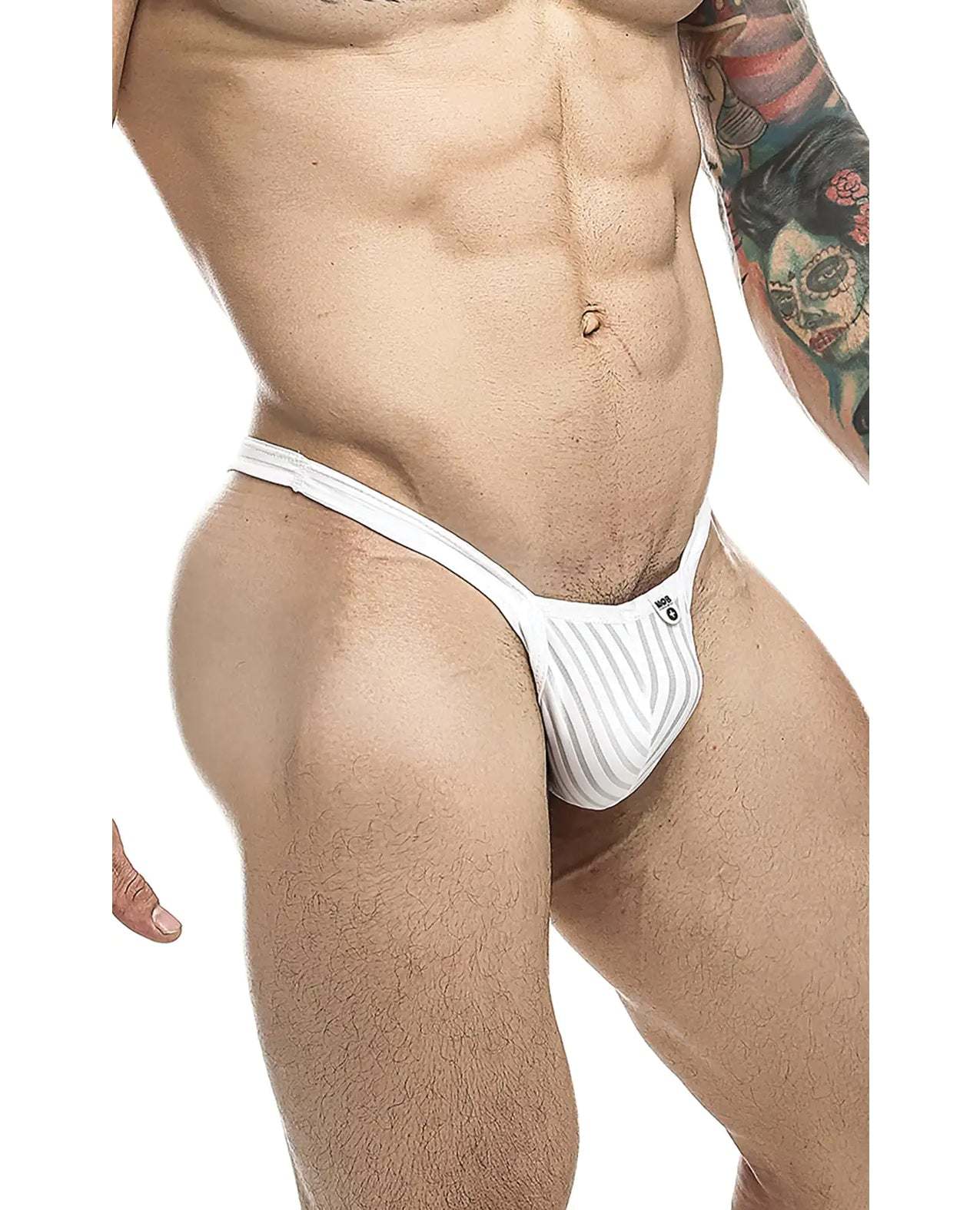 Male model wearing white sheer Male Basics Y Buns Thong showcasing slim V-strap design and minimal coverage.