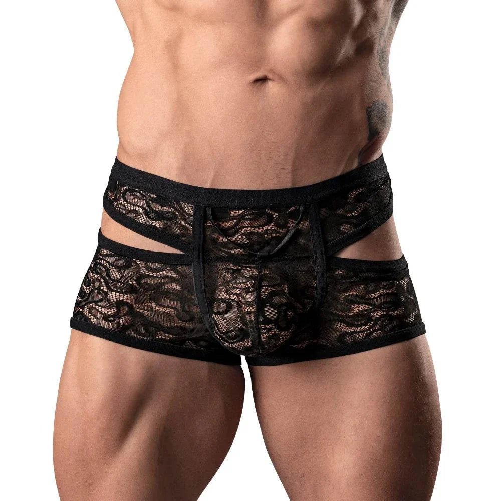 Male model wearing black Male Power Lucifer Cutout Short lace underwear with peek-a-boo cutouts and floral pattern.