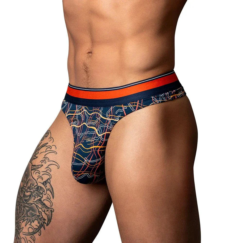 Male model wearing Male Power Soo Cumfy Thong in navy and orange with marble print and supportive contour pouch