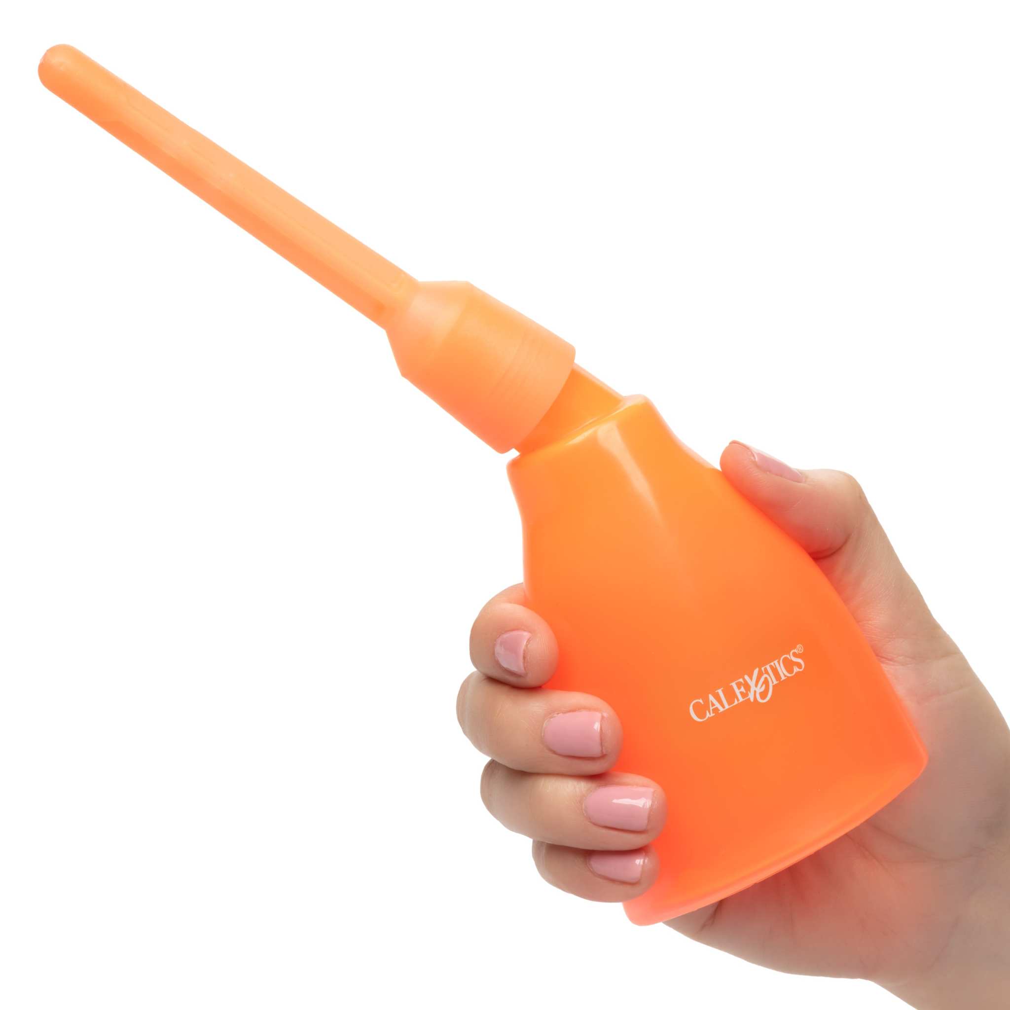 Hand holding the bright orange reusable Ultimate Douche with a slim nozzle for intimate hygiene care