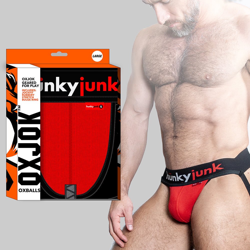 Red Oxballs Hunker Jockstrap with comfy pouch and slider strap design, worn by male model, shown with packaging box.