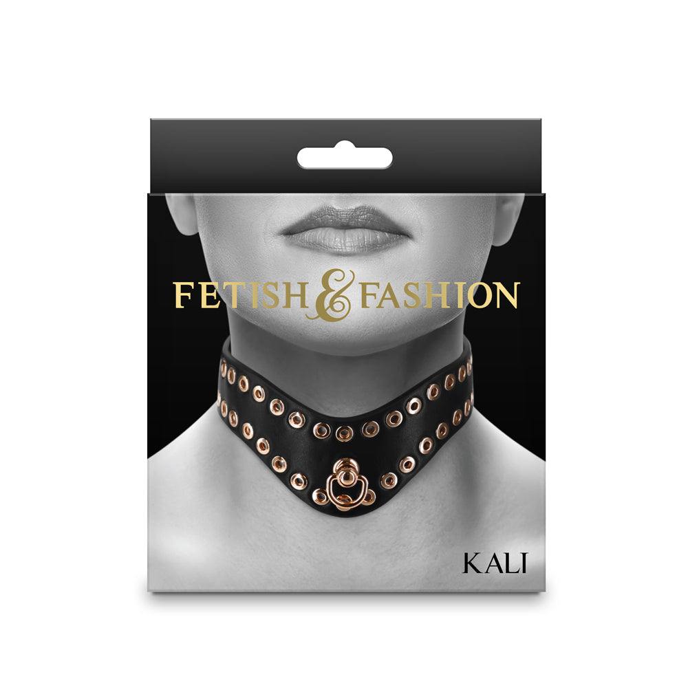 Black Fetish & Fashion Kali Collar with hollow golden studs and adjustable buckle closure displayed on packaging.