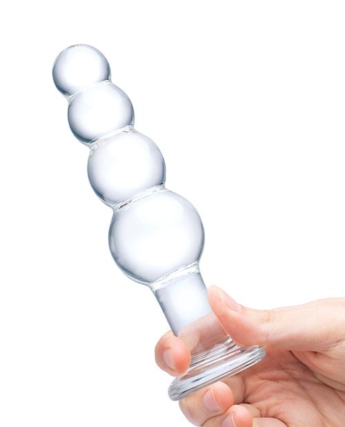 Clear Glas 7.25-inch glass beaded butt plug with graduated spheres and flared base held by hand for intimate use