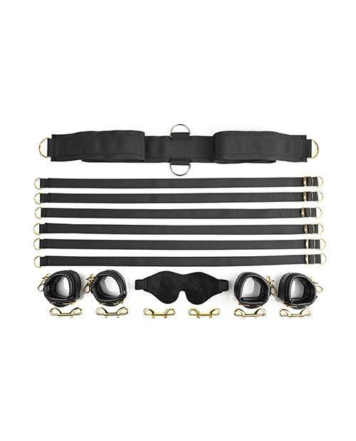 Under the bed restraint system with adjustable straps, faux leather cuffs, golden hardware, and a velvet blindfold for bondage play.