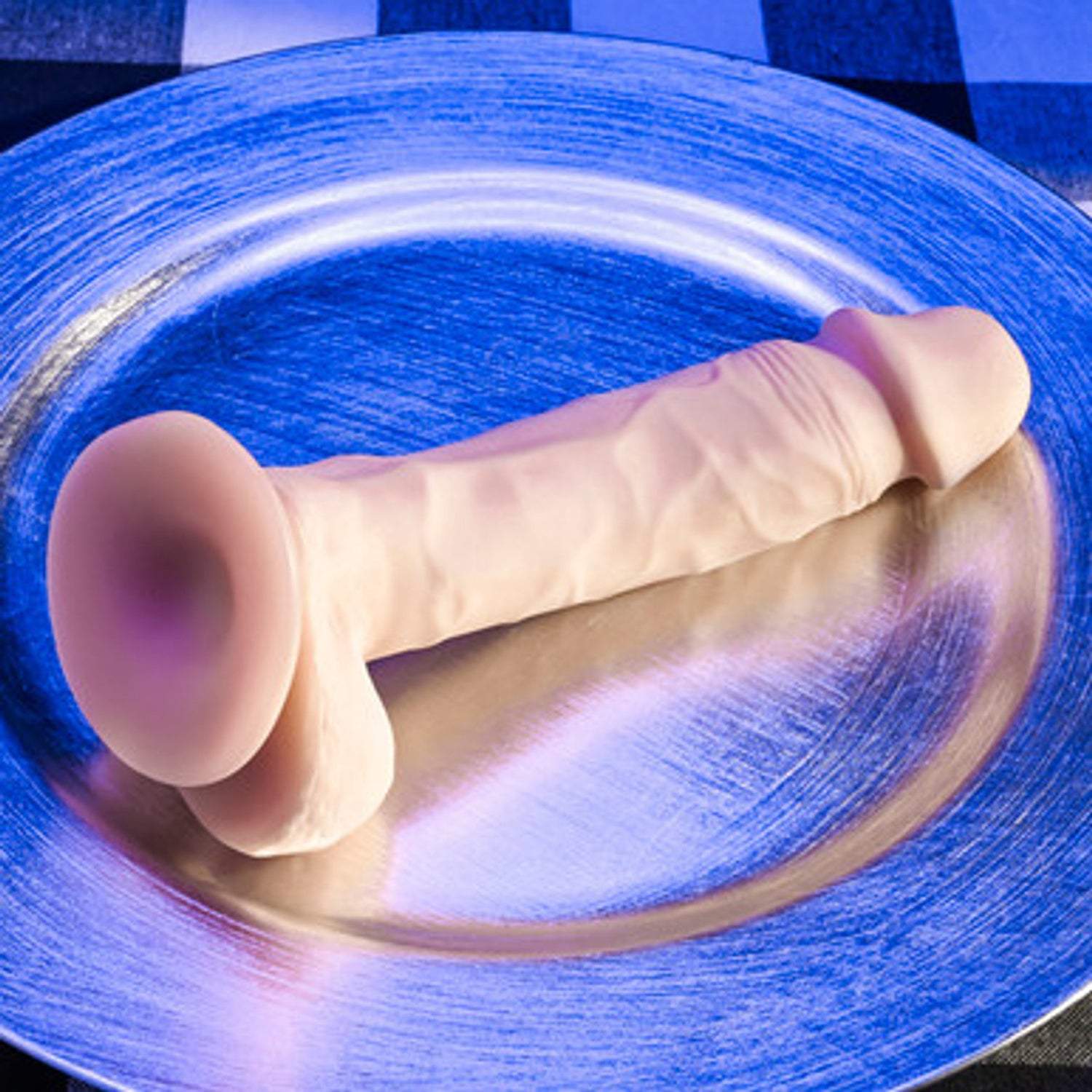 Natural Feel Dildo Light 6.5 inch realistic dual-layered TPE dildo with suction cup base on blue plate