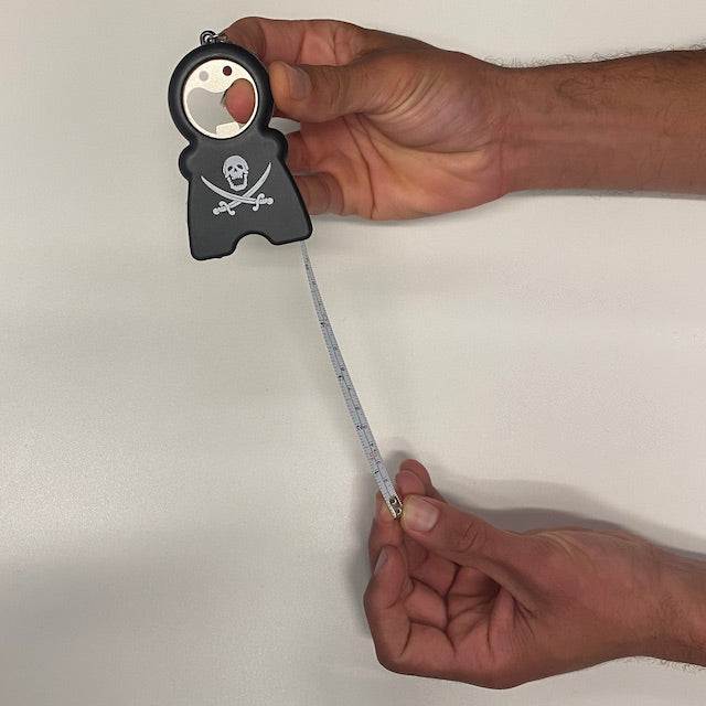 TIM 4-in-1 Keychain with tape measure, skull design, and compact multifunction tool held in hands