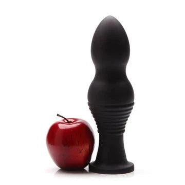 Tantus Piggy XL Premium Silicone Plug with tapered design and flared base, alongside a red apple for size comparison.