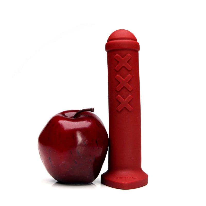 Tantus Amsterdam Junior Premium Silicone Dildo in Ruby Red next to an apple, showcasing size and color contrast.